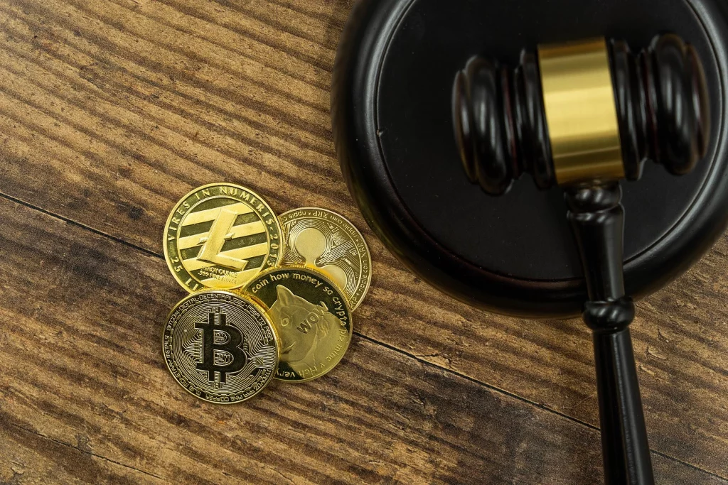 Judge's gavel and gold coins with cryptocurrencies 